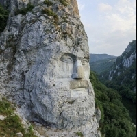 A huge portrait of an ancient king looms over the river.