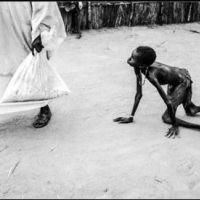 Głód w Sudanie Południowym, 1998, mężczyzna skonfiskował jedzenie chłopcu, który  za porywaczem może tylko czołgać.