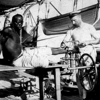 Marynarz statku Royal Navy HMS Sphinx zdejmuje kajdany z uratowanego afrykańskiego niewolnika w październiku 1907 roku.