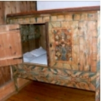Łóżko skrzynkowe jest małym, podwyższonym łóżkiem, całkowicie zabudowanym w drewnie.