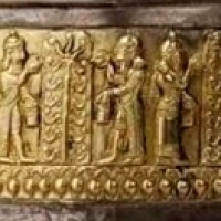 W reliefie na złotej aplikacji widzimy bogów inseminujących święte drzewa.