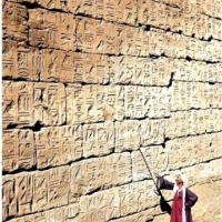 Przewodnik ze wskaźnikiem na ścianie pełnej inskrypcji z hieroglifami w Świątyni Luksorskiej, 1950 r.⁣